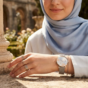 Elegant woman wearing Tommy Hilfiger 1782604 women's quartz battery watch with silver case and luxury rose gold accented dial