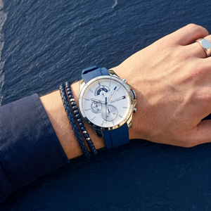 Close up of Tommy Hilfiger Decker 1791349 men's quartz battery watch on wrist showing white multi-function dial and blue rubber strap