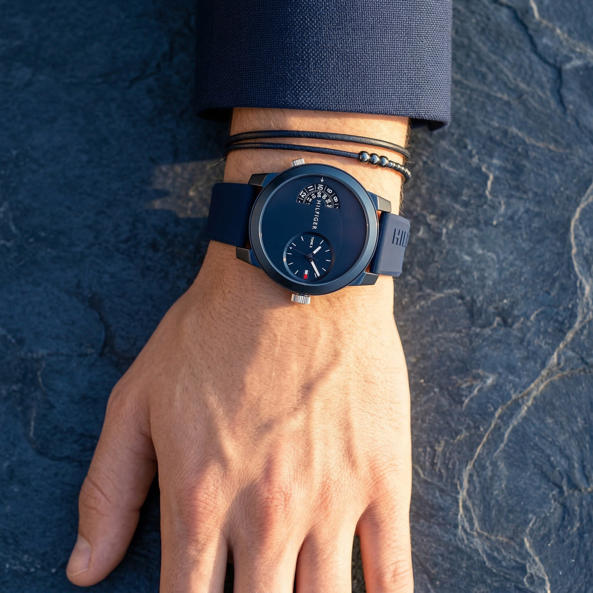 Close up of Tommy Hilfiger Denim 1791556 men's quartz battery watch on wrist showing unique blue dual-time dial and blue rubber strap