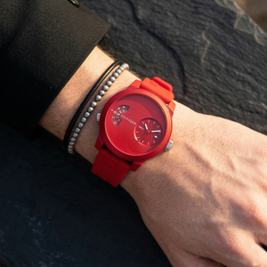 Close up of Tommy Hilfiger Denim 1791557 men's quartz battery watch on wrist showing unique red dual-time dial and red rubber strap