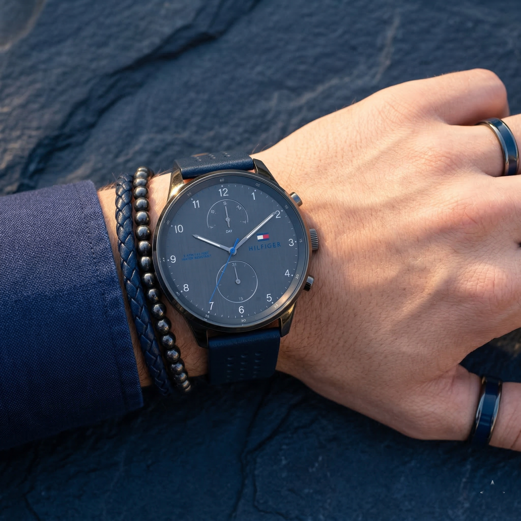 Close up of Tommy Hilfiger Chase 1791578 men's quartz battery watch on wrist showing gray textured dial and blue leather strap