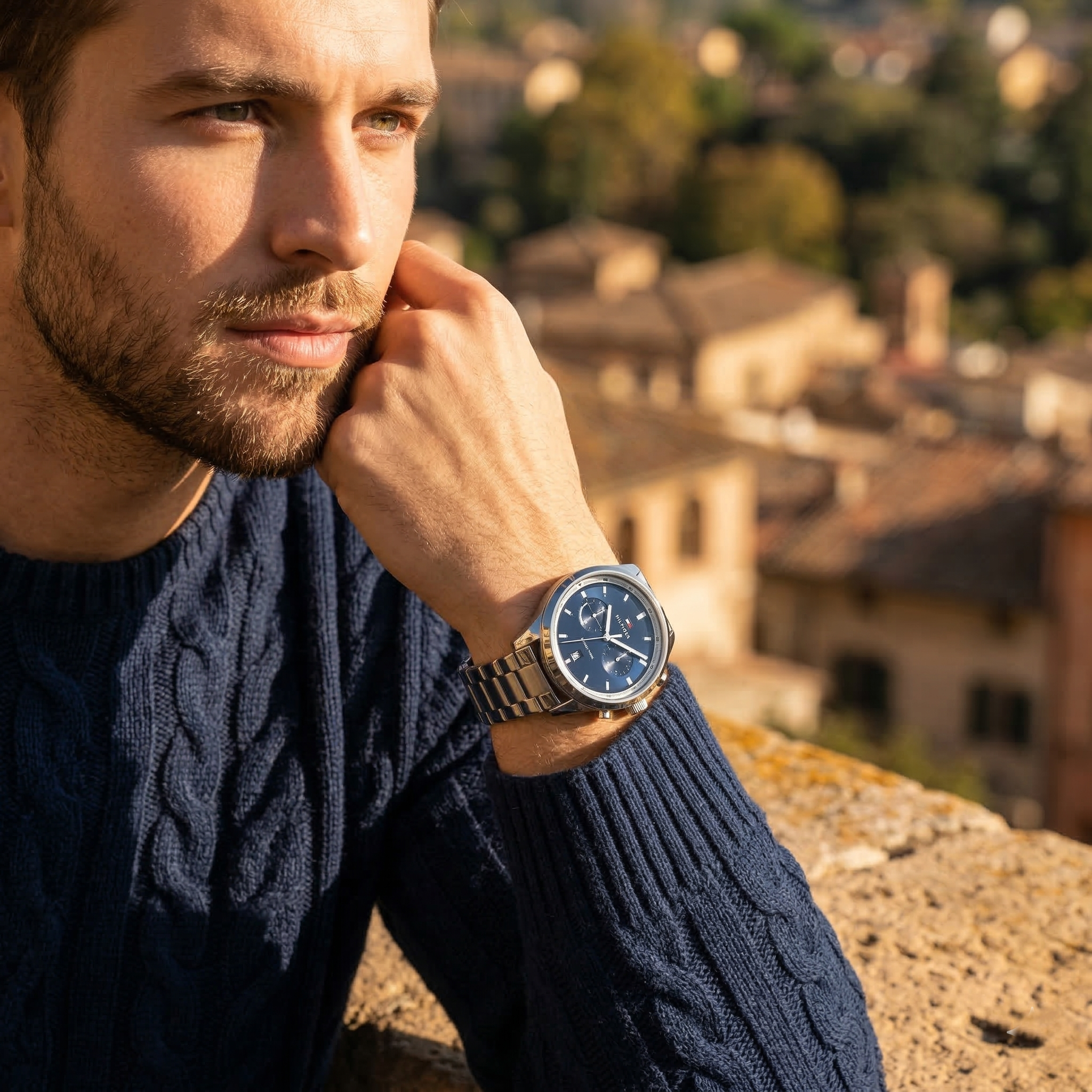 Elegant man wearing Tommy Hilfiger Bennett 1791725 men's quartz battery watch with silver-tone case and luxury blue dial