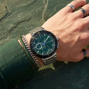 Close up of Tommy Hilfiger Lorenzo 1792117 men's quartz battery watch on wrist showing emerald green sunray dial and silver metal bracelet