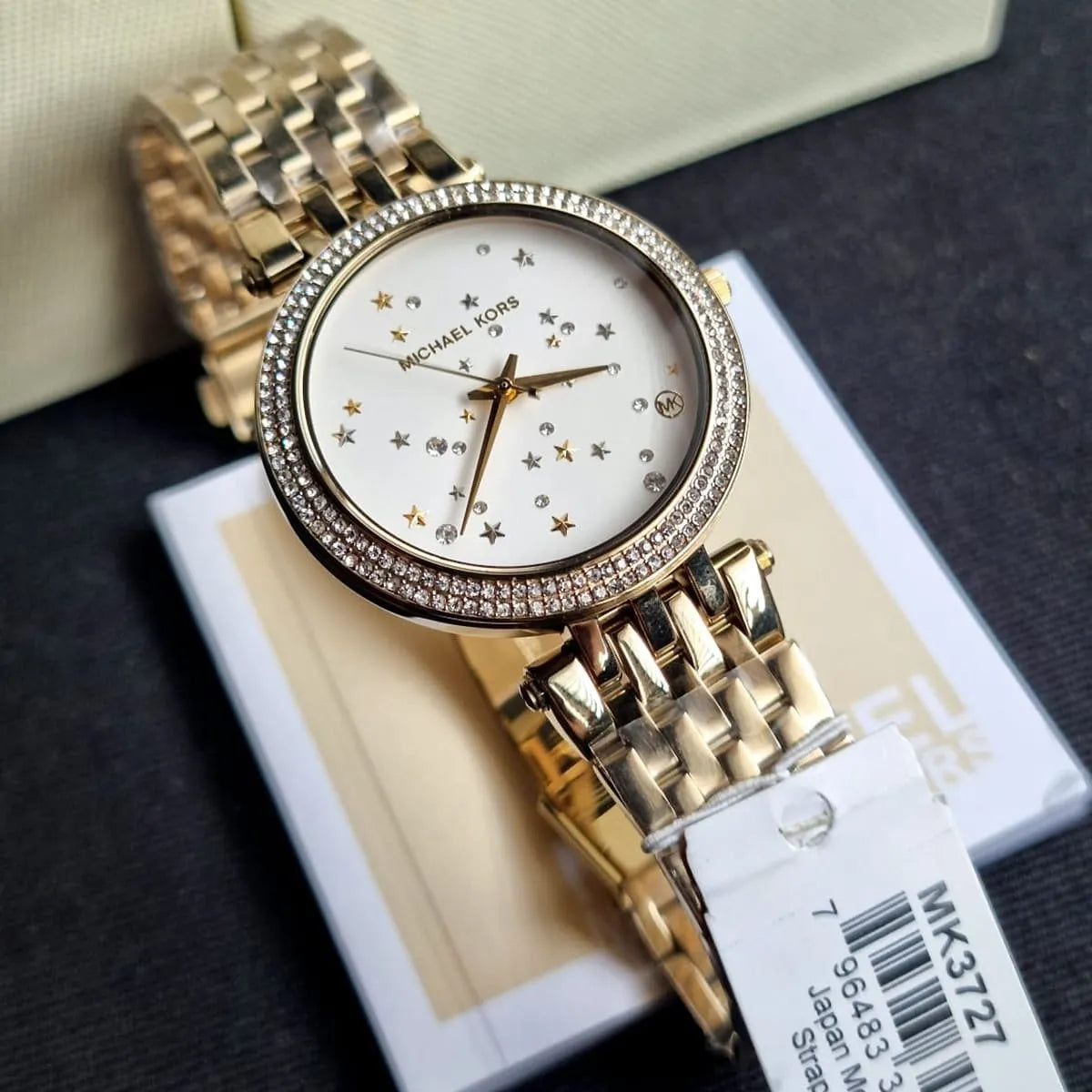 Extreme close-up of Michael Kors MK3727 showing gold sunray dial and pavé crystals