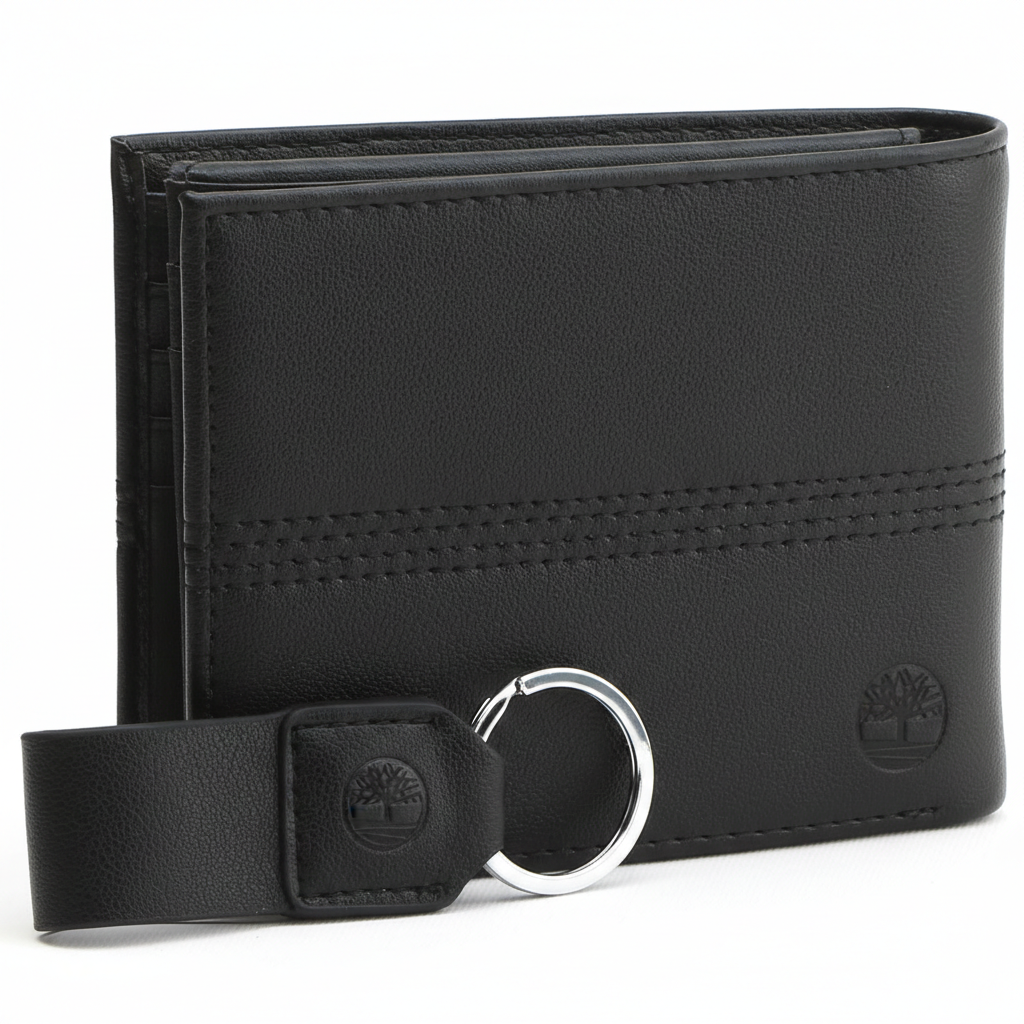 Side perspective of a standing Timberland black leather bifold wallet highlighting the vertical stitch detail and embossed tree logo next to its matching keychain