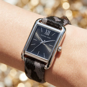 Lifestyle photo of Michael Kors MKo1199 showing the elegant grey leopard print watch on a woman's wrist