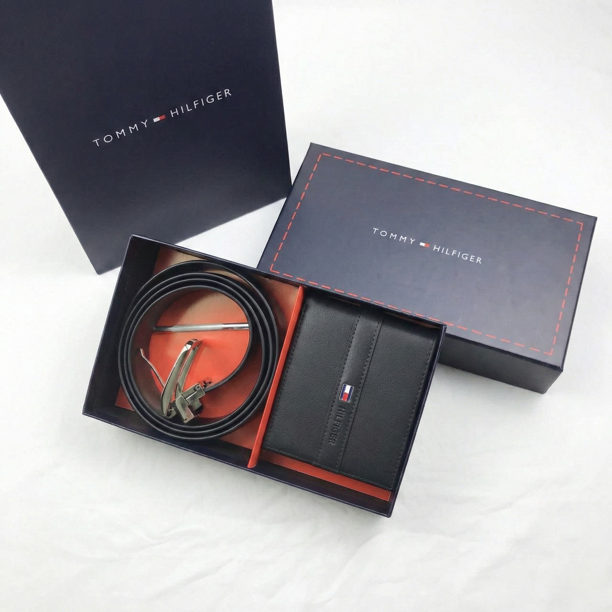 Tommy Hilfiger belt and wallet set in open boxes on a white background