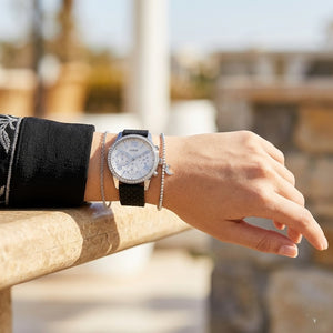 Close up of Guess Sunrise W1135L5 women's multi-function watch (Silver Cushion Case and Black Rubber Strap variant) on wrist showing deep silver-white dial with multi-function display and luminous indices