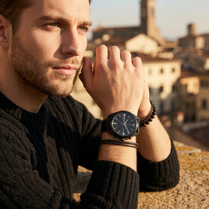 Elegant man wearing Emporio Armani Claudio AR11483 men's quartz battery watch with black-tone case and luxury leather strap