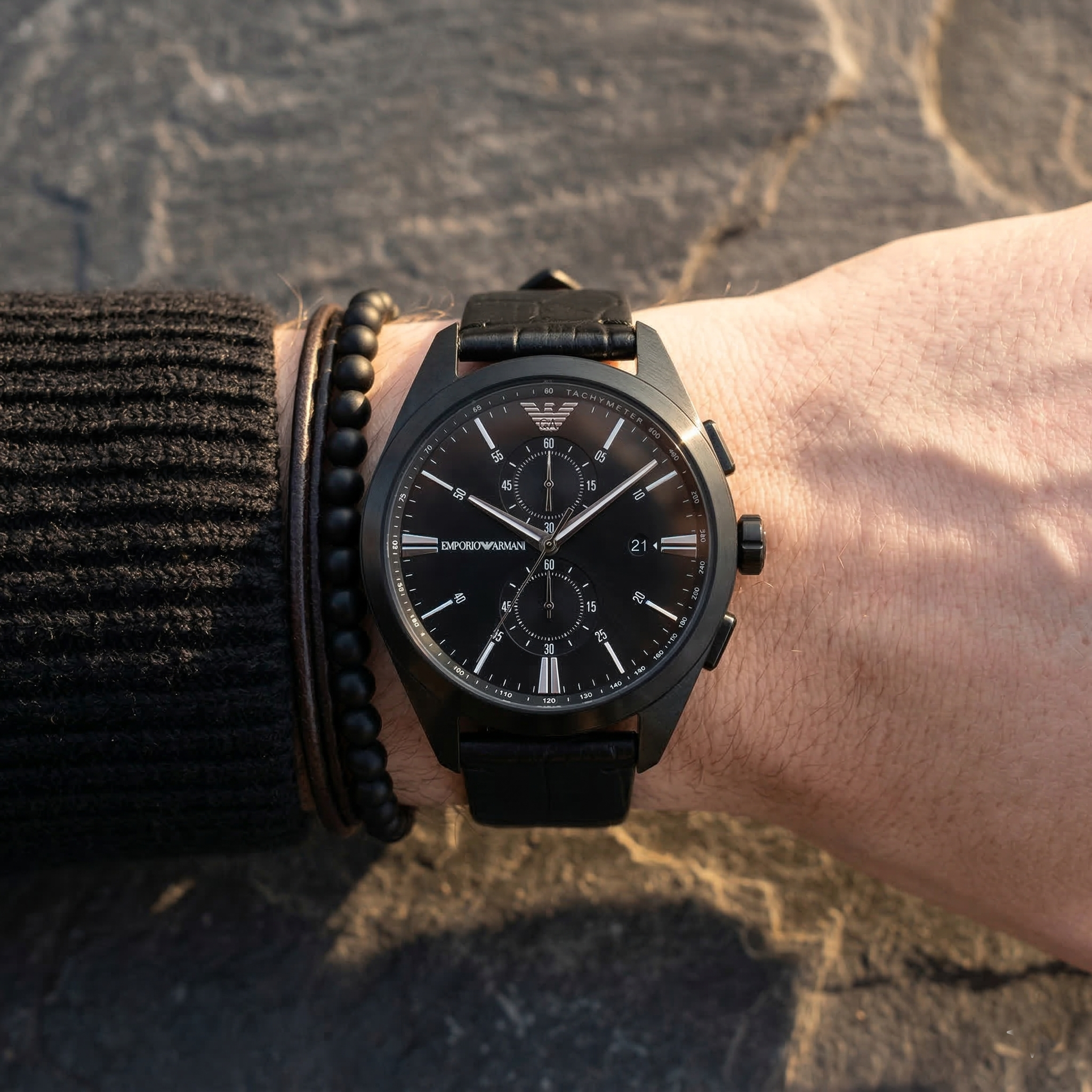 Close up of Emporio Armani Claudio AR11483 men's quartz battery watch on wrist showing black chronograph dial and black leather strap