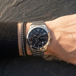 Close up of Emporio Armani Paolo AR11602 men's quartz battery watch on wrist showing black textured dial and silver metal bracelet
