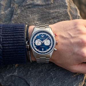 Close up of Emporio Armani Racer AR11676 men's quartz battery watch on wrist showing blue chronograph dial and silver metal bracelet