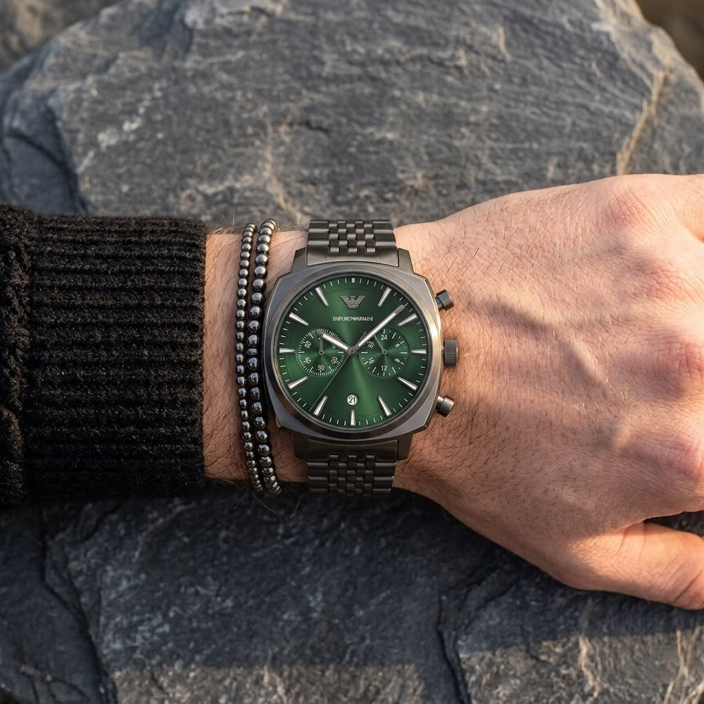 Close up of Emporio Armani Carlo AR11689 men's quartz battery watch on wrist showing emerald green dial and luxury silver eagle logo