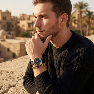 Elegant man wearing Emporio Armani Carlo AR11690 men's quartz battery watch with gold cushion case and luxury black leather strap