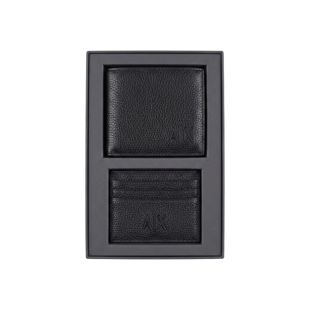 Live smartphone photograph of the Armani Exchange AX mirror original 2-piece gift set showcasing the black leather wallet with silver logo and matching metal keychain inside the custom black and red box tray