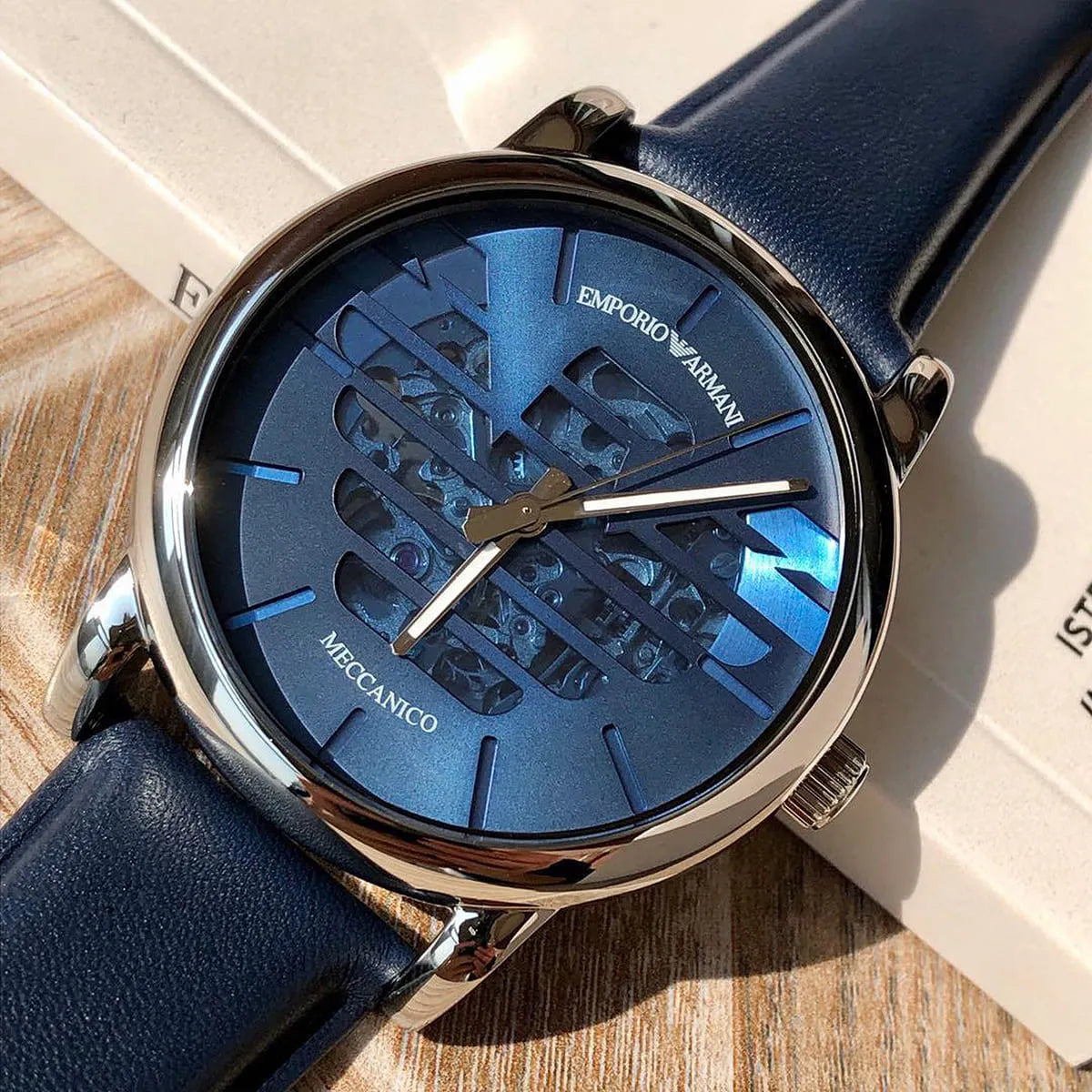Close-up of the silver-tone Emporio Armani logo and Meccanico branding on the AR60030 blue dial