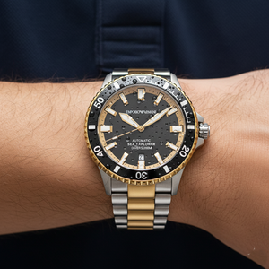 Macro shot of the Armani AR60089 black dial showing gold-tone luminous markers and automatic text