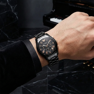 Man wearing Emporio Armani AR1410 black ceramic watch with black velvet tuxedo