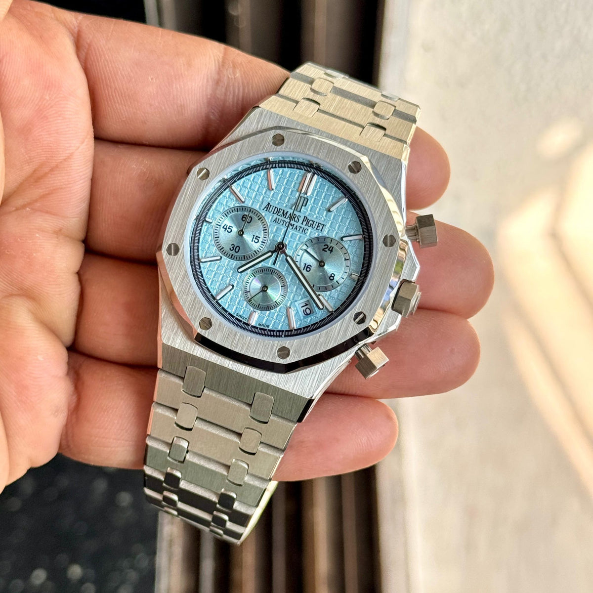 Audemars Piguet Royal Oak men's chronograph watch, light blue dial, silver stainless steel bracelet – in-hand angle view