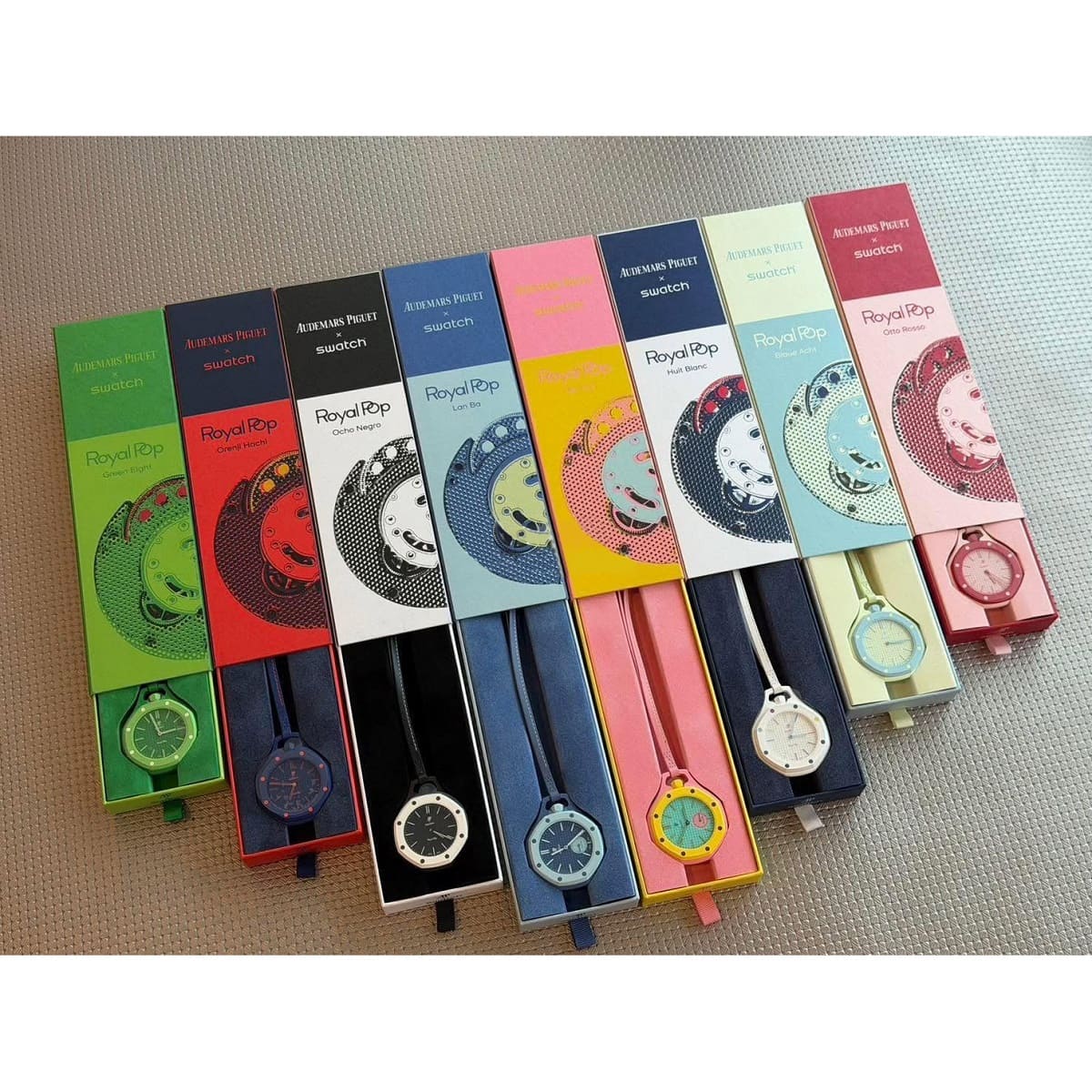Six Royal Pop Quartz wristwatches in different colorways, displayed in their original retail packaging on a textured beige fabric background.