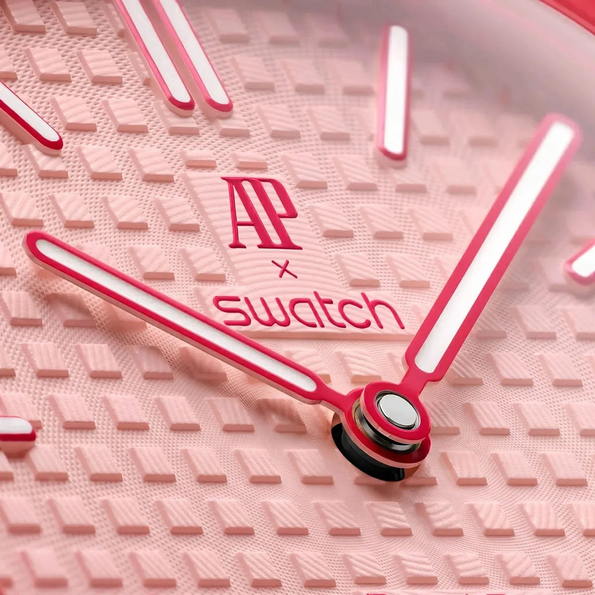 Close-up of a pink Swatch watch face with brand logo