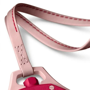 Close-up of a pink luggage tag with red accents on a white background