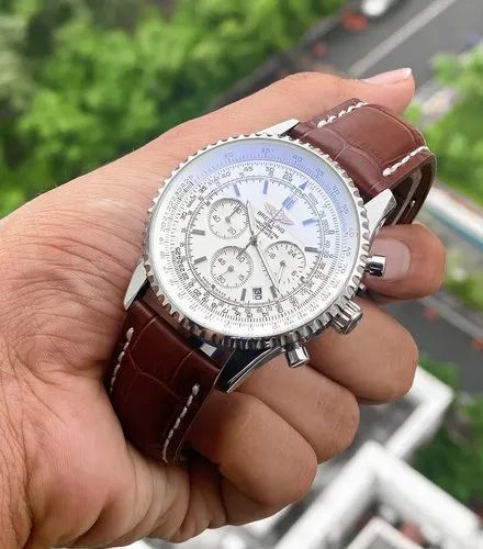Breitling Navitimer 46mm men's chronograph watch, 46mm stainless steel case, white dial, brown leather strap – hand-held angle view