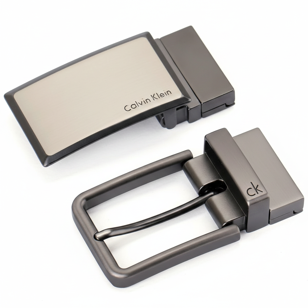 High-detail view of the two premium metal buckles included in the Calvin Klein belt gift set: a sleek plaque buckle and a classic pin buckle