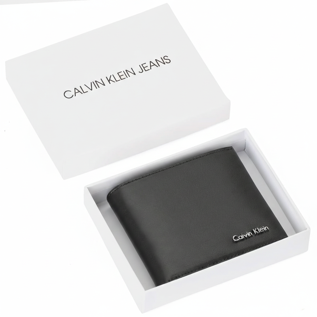 Top-down view of a Calvin Klein men's black smooth leather bifold wallet featuring a silver metal logo, presented inside its original white branded gift box