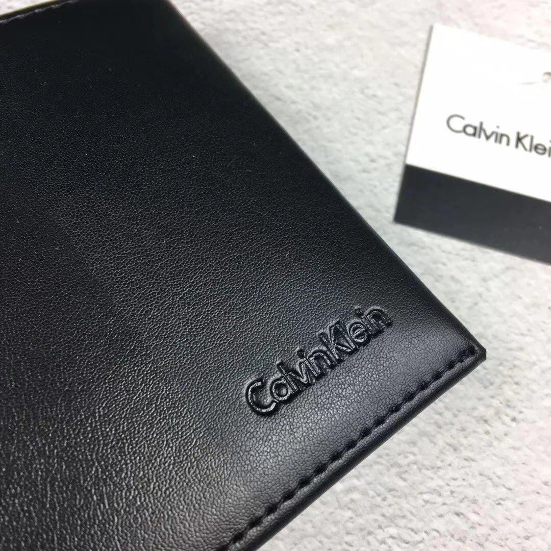 Close-up high-angle view of a Calvin Klein men's black leather wallet showcasing the stylish matte vertical stripe pattern and the small debossed Calvin Klein logo