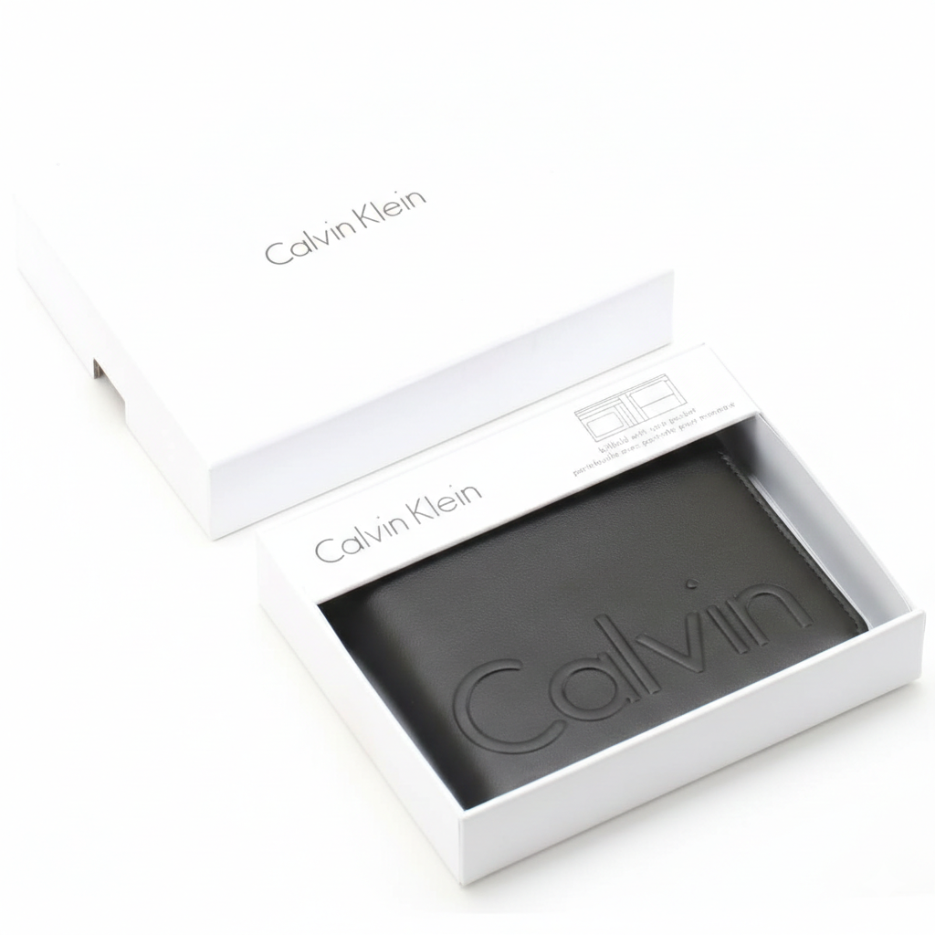 A Calvin Klein men's black leather wallet with debossed Calvin lettering, elegantly presented inside an open white branded gift box