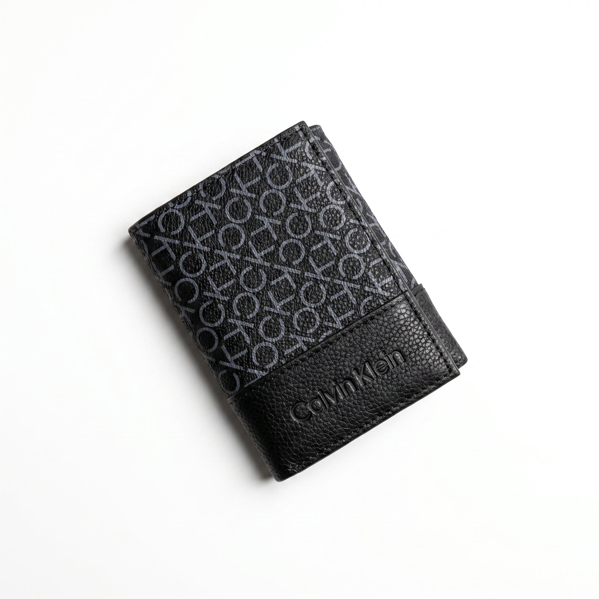 Professional angled studio photograph of the sleek Calvin Klein mirror original grey printed monogram bi-fold leather wallet