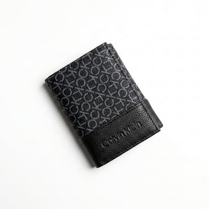 Professional angled studio photograph of the sleek Calvin Klein mirror original grey printed monogram bi-fold leather wallet