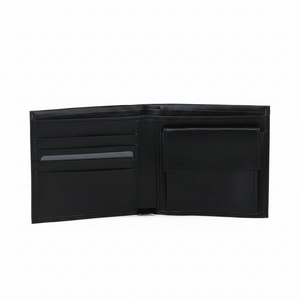 Angled open interior view of a Calvin Klein Jeans men's black leather wallet showcasing multiple card slots on the right and a snap-button coin pocket on the left