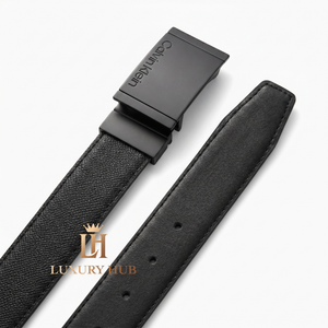 Ultra-realistic close-up of the Calvin Klein matte black plaque buckle featuring the precision-engraved brand logo