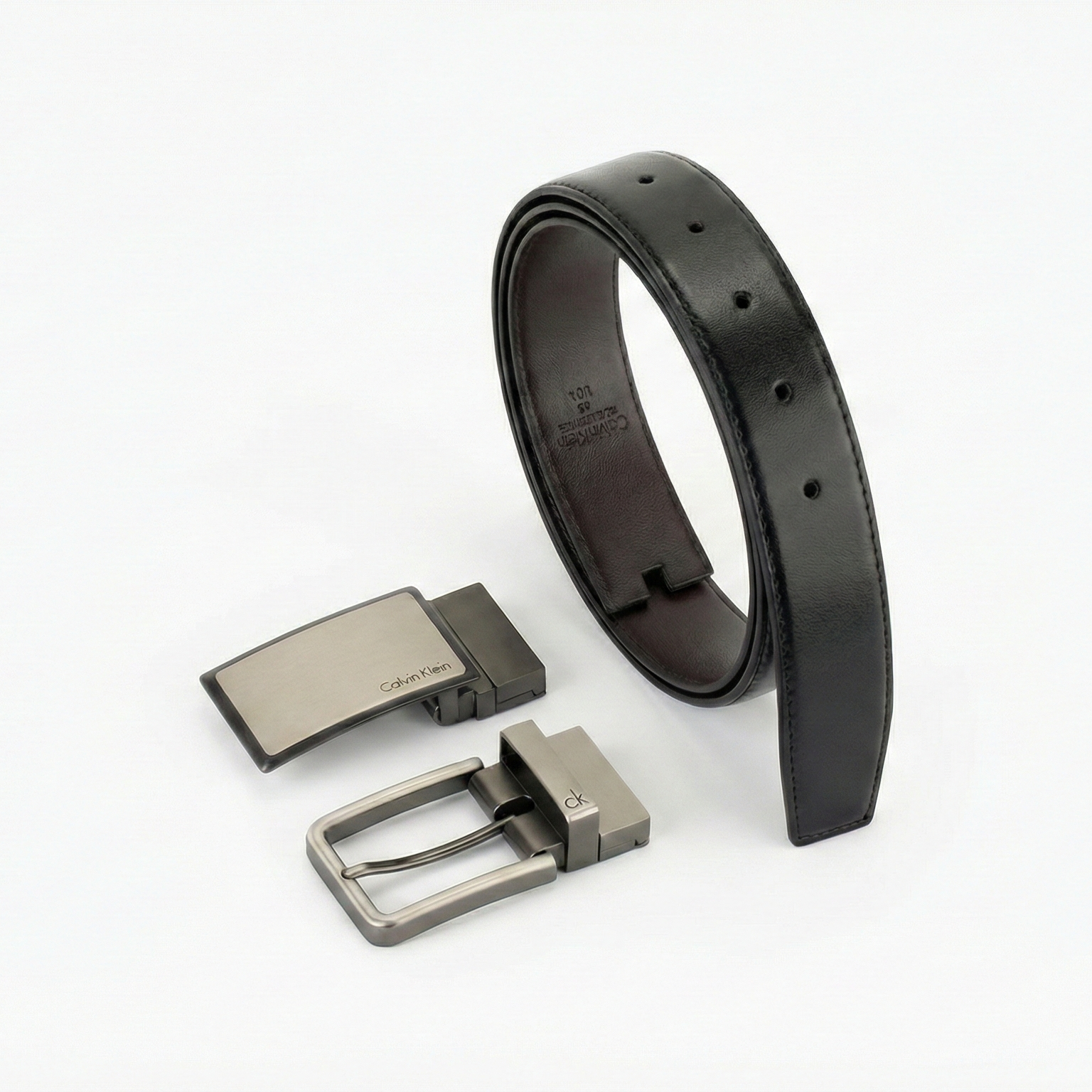 Perspective view of the Calvin Klein men's leather belt gift set showing the premium black side with two interchangeable gunmetal buckles