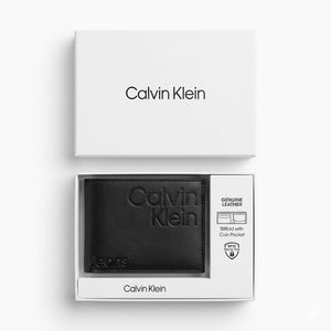 Top-down studio product photography of the Calvin Klein Jeans mirror original smooth black leather wallet neatly resting inside its open custom white branded gift box