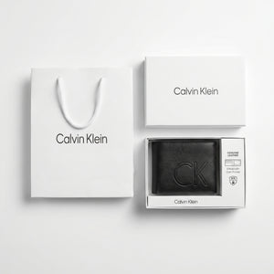 Full premium packaging presentation of the Calvin Klein mirror original smooth black leather bifold wallet alongside its white gift box and matching shopping bag
