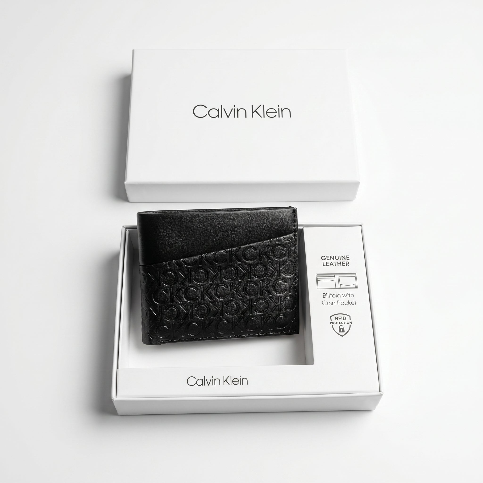 Top-down studio product photography of the Calvin Klein smooth black leather bifold wallet neatly resting inside its custom white branded packaging