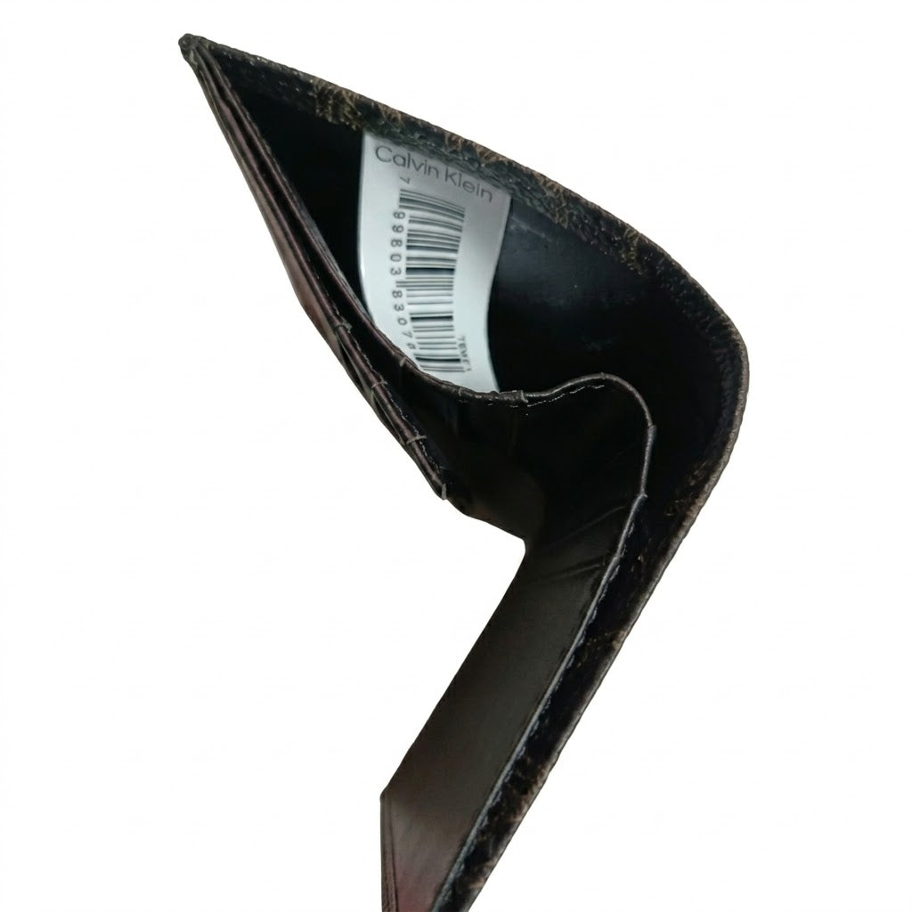 High-angle interior view of the opened Calvin Klein leather wallet currency compartment highlighting the original white tracking barcode label and fabric lining