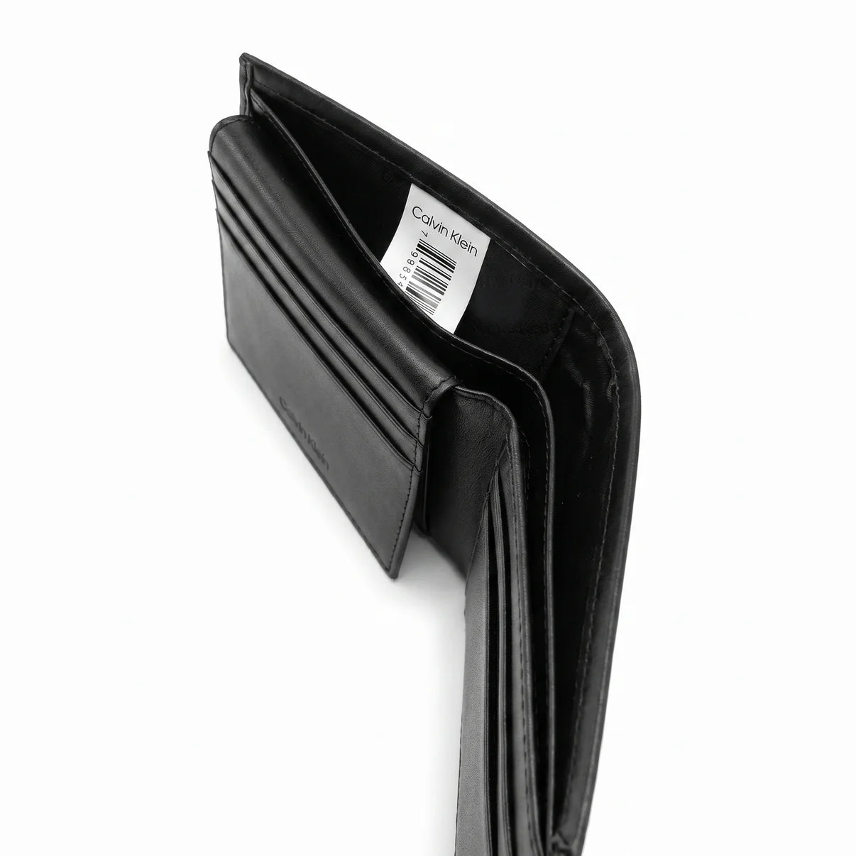 High-angle interior view of the opened Calvin Klein leather wallet currency compartment highlighting the original white tracking barcode label and fabric lining