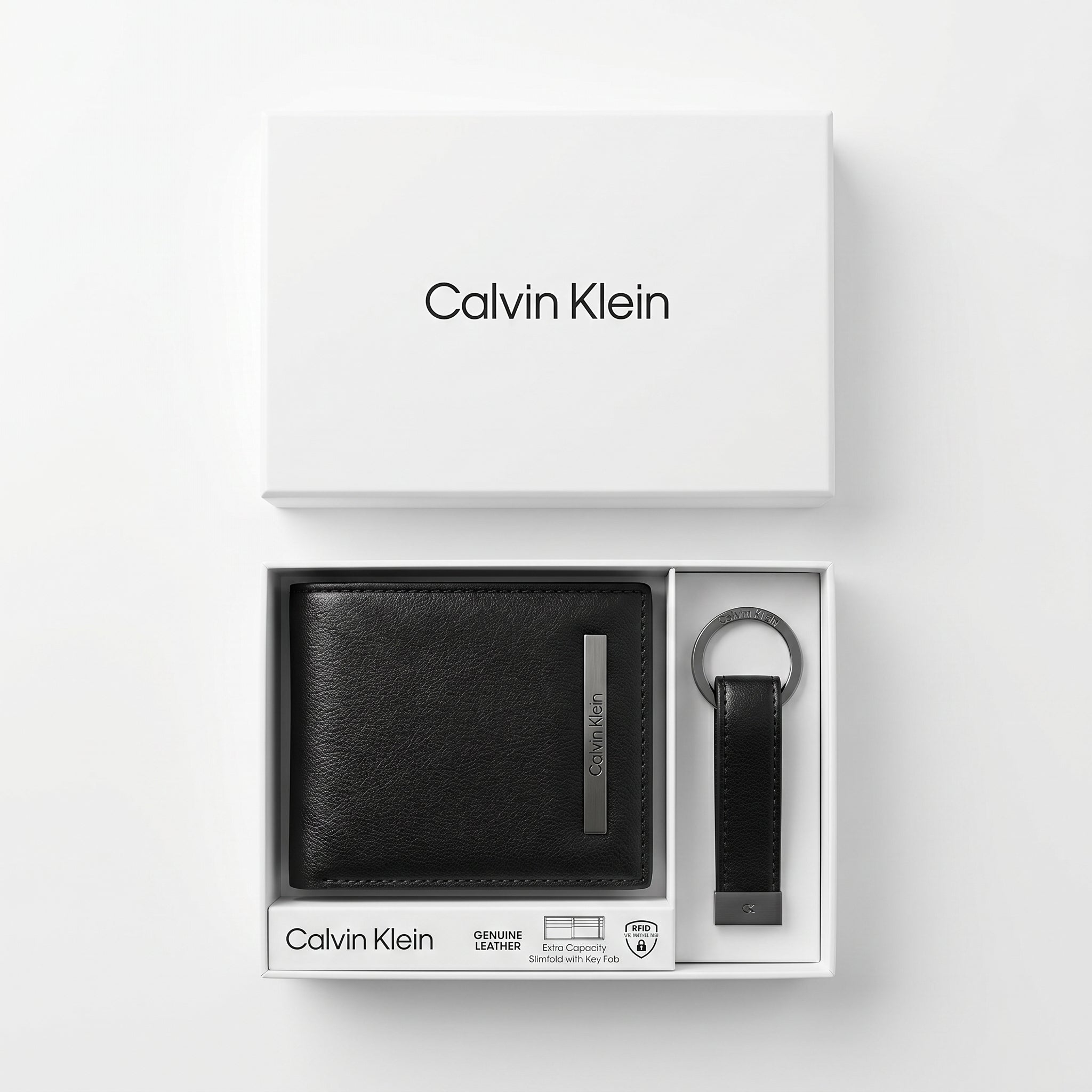 Top-down studio product photography of the Calvin Klein mirror original smooth black leather wallet and keychain set neatly resting inside its open white branded gift box