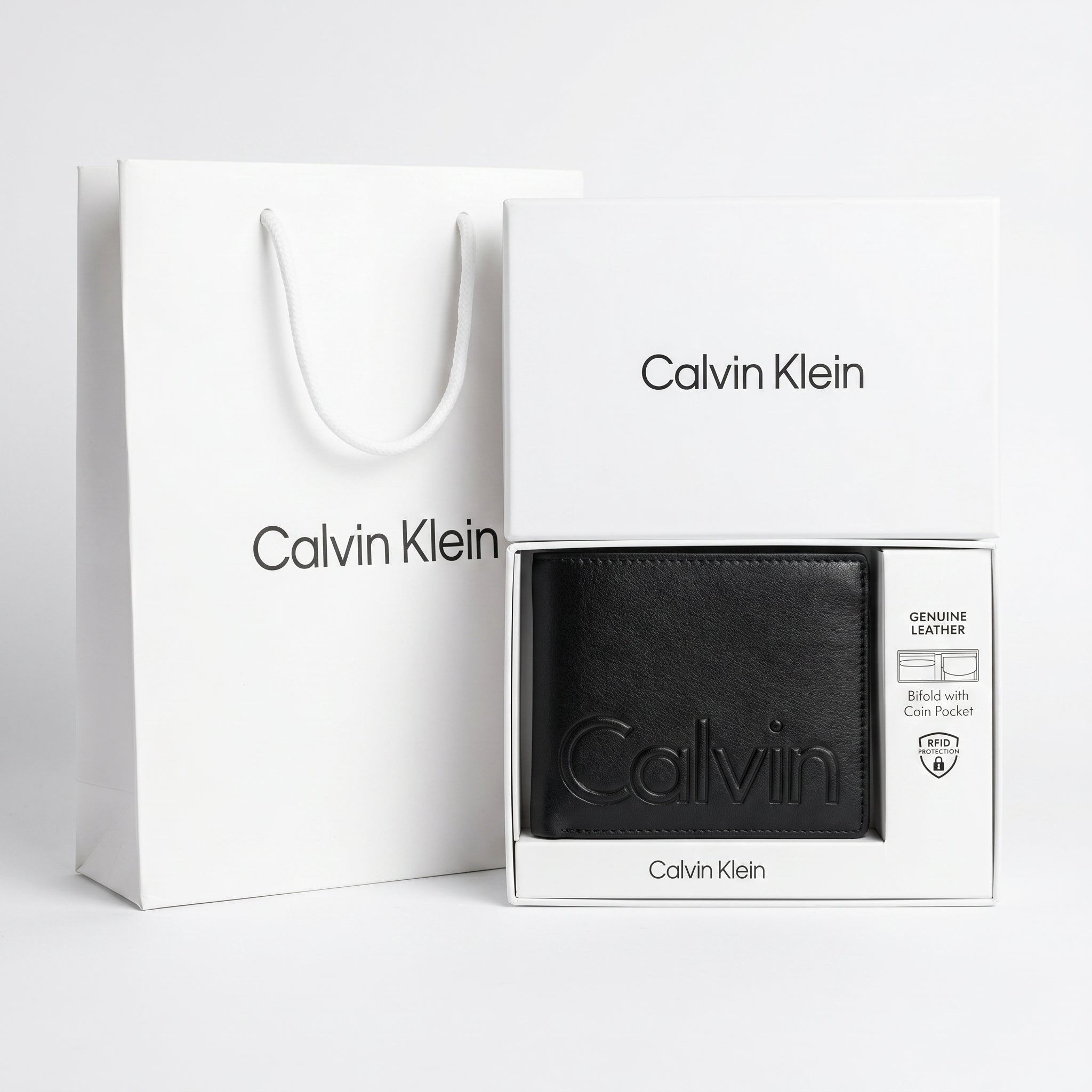 Full premium packaging presentation of the Calvin Klein mirror original smooth black leather wallet with its white gift box and matching shopping bag