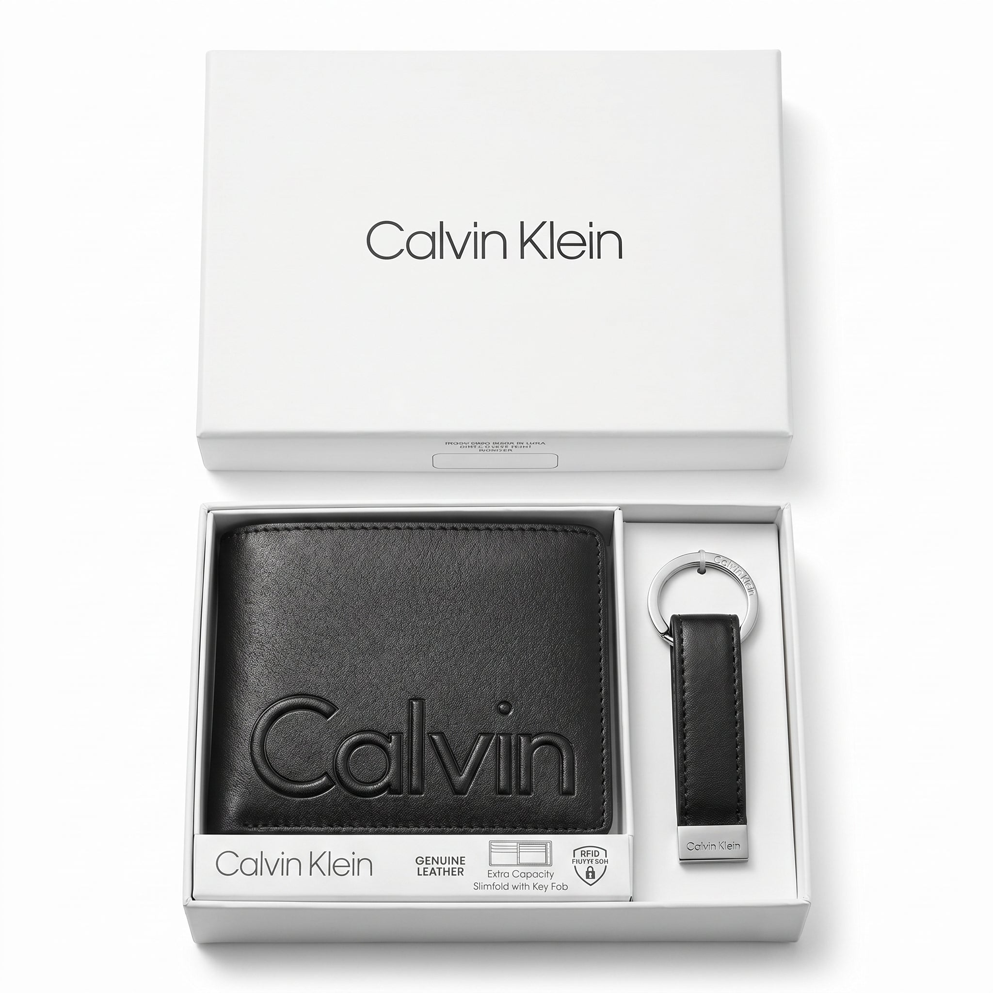 Top-down studio product photography of the Calvin Klein mirror original smooth black leather wallet and matching keychain set neatly arranged inside its open white branded gift box