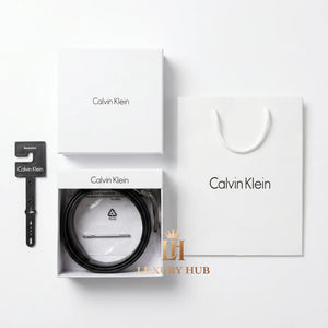 Top view product photography of the Calvin Klein reversible leather belt set presented in its signature white gift box