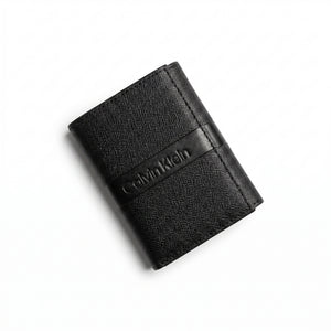 Professional angled studio photograph of the sleek Calvin Klein mirror original saffiano bi-fold leather wallet