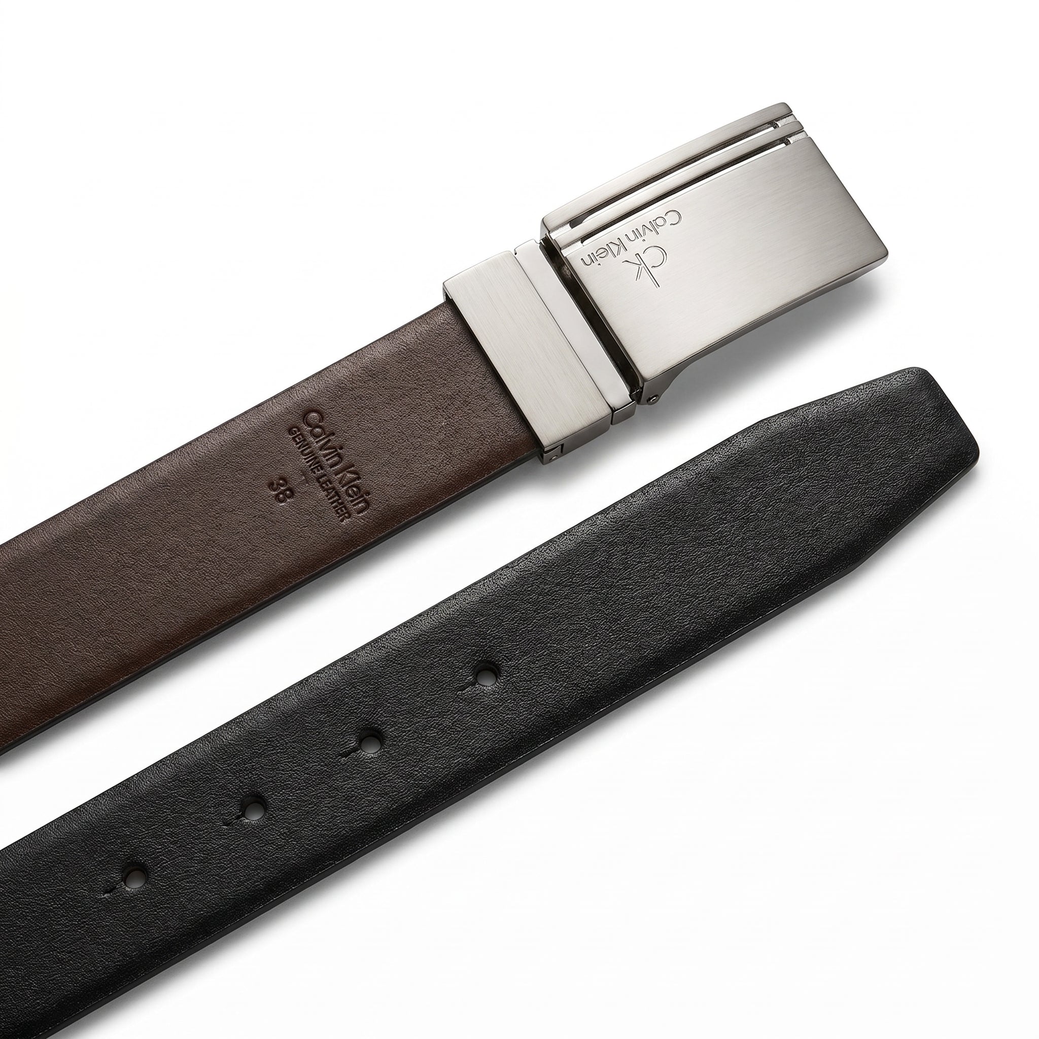 Detailed close-up of the Calvin Klein silver-toned plaque buckle showing the precision engraved ck brand logo