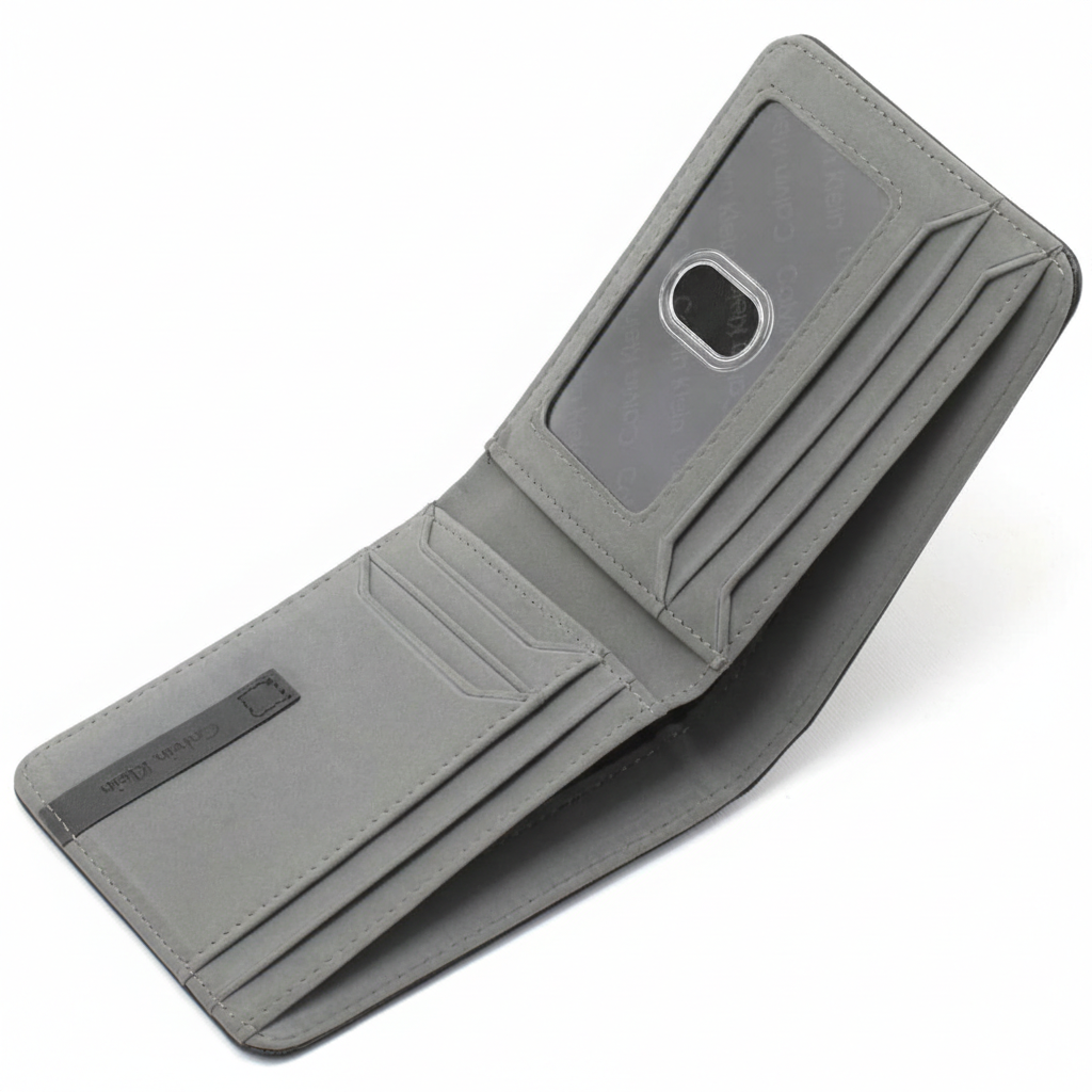 Angled interior view of an open Calvin Klein men's wallet showcasing the distinctive grey leather finish, multiple card slots, and an attached passcase with a clear ID window