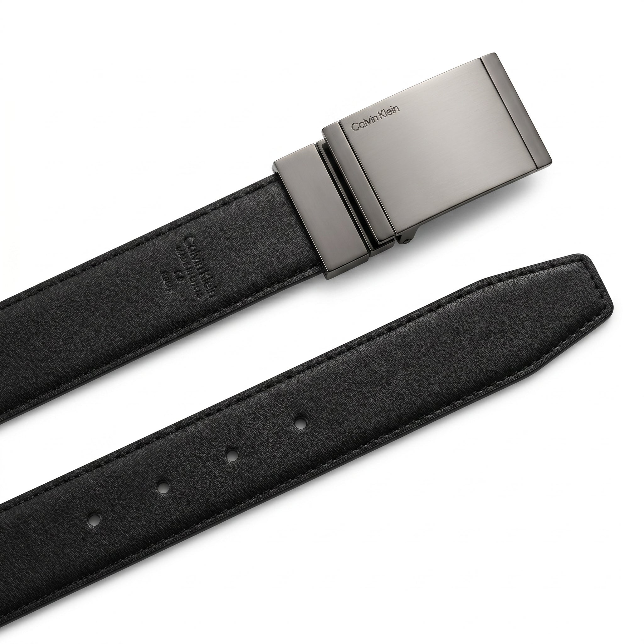 Detailed close-up of the Calvin Klein matte black plaque buckle showing the precision engraved brand logo