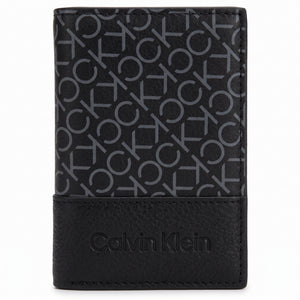 Macro close-up view showing the grained leather texture and precision engraved Calvin Klein branding at the bottom of the wallet
